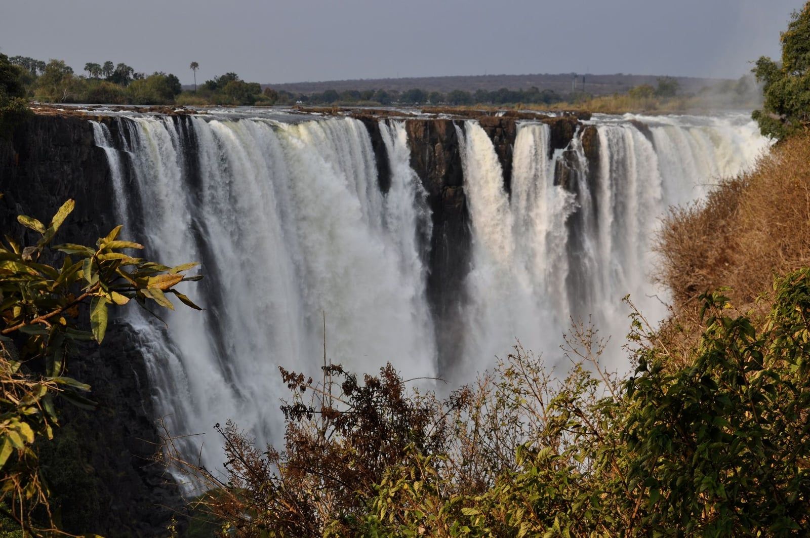 A powerful curtain of water cascades down the sheer cliffs of Victoria Falls, an iconic destination often visited alongside Hwange National Park.